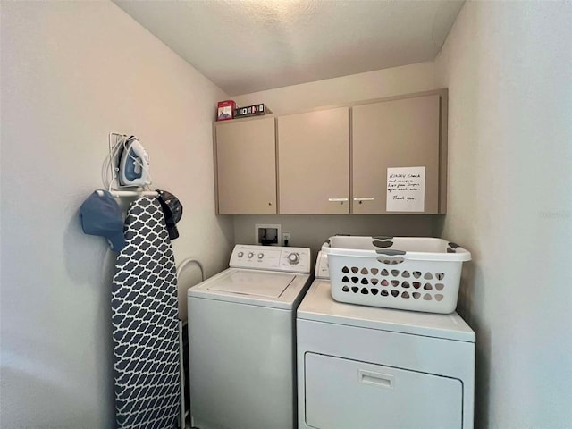 laundry room featuring washing machine and clothes dryer and cabinet space