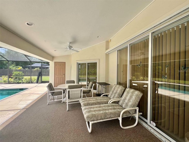 view of patio featuring glass enclosure, ceiling fan, and a fenced in pool