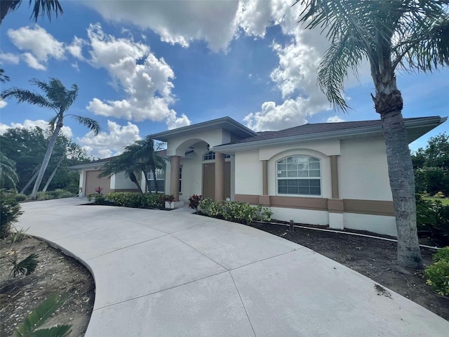 view of front facade with stucco siding, a garage, and concrete driveway