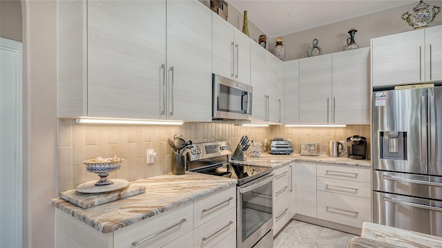 1085 Mallard Marsh Dr, Osprey, FL 34229 - kitchen featuring white cabinetry, decorative backsplash, marble finish floor, light stone countertops, and appliances with stainless steel finishes