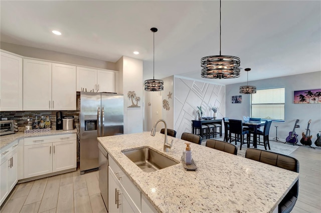 15719 Barefoot Beach Dr, Lakewood Ranch, FL 34211 - kitchen featuring stainless steel appliances, white cabinets, tasteful backsplash, recessed lighting, and hanging light fixtures