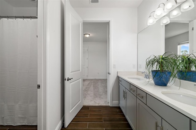 4712 Margutta Ct, Sarasota, FL 34240 - bathroom with double vanity, wood finished floors, and baseboards