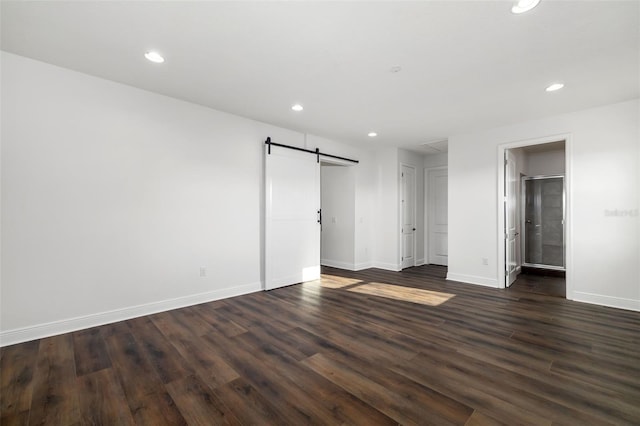 4712 Margutta Ct, Sarasota, FL 34240 - unfurnished bedroom featuring a barn door, recessed lighting, baseboards, and dark wood-style floors
