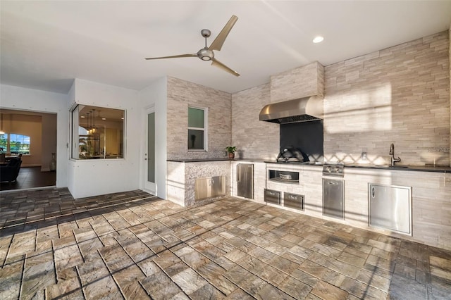 4712 Margutta Ct, Sarasota, FL 34240 - kitchen featuring wall chimney exhaust hood, a ceiling fan, a sink, and stone finish flooring
