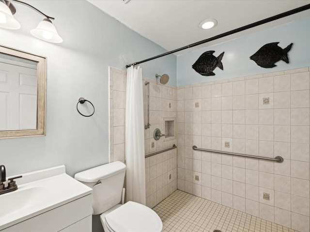 full bathroom with a tile shower, vanity, and toilet