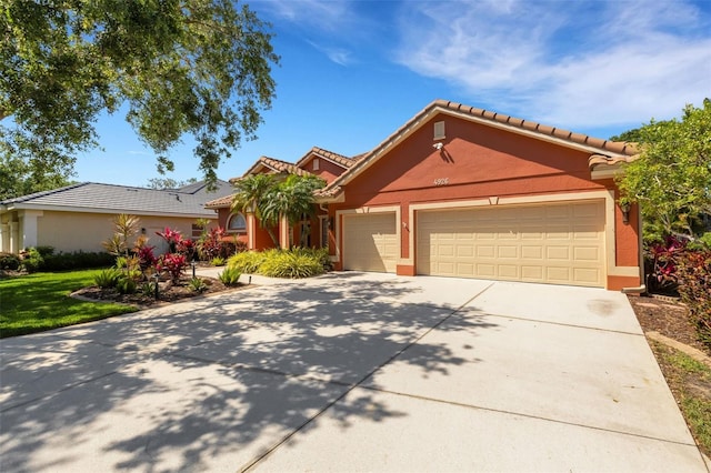 view of front facade featuring driveway, stucco siding, an attached garage, and a tile roof