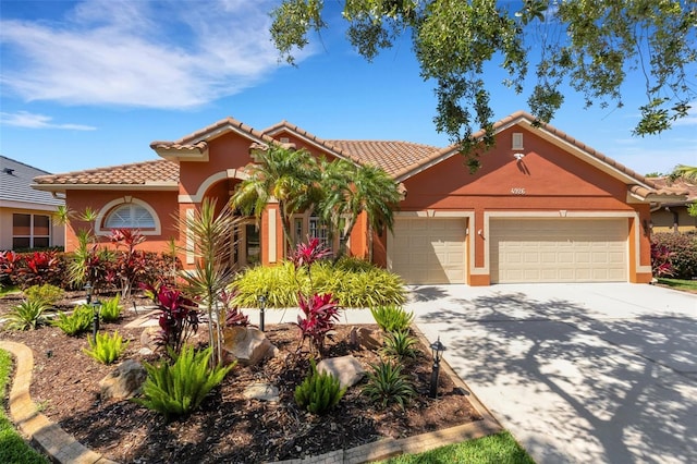 mediterranean / spanish house featuring a tile roof, an attached garage, driveway, and stucco siding