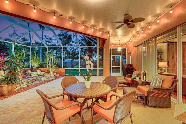 sunroom / solarium featuring track lighting, a ceiling fan, and an outdoor hangout area