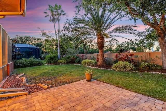 view of yard with a fenced backyard, a patio, and a lanai