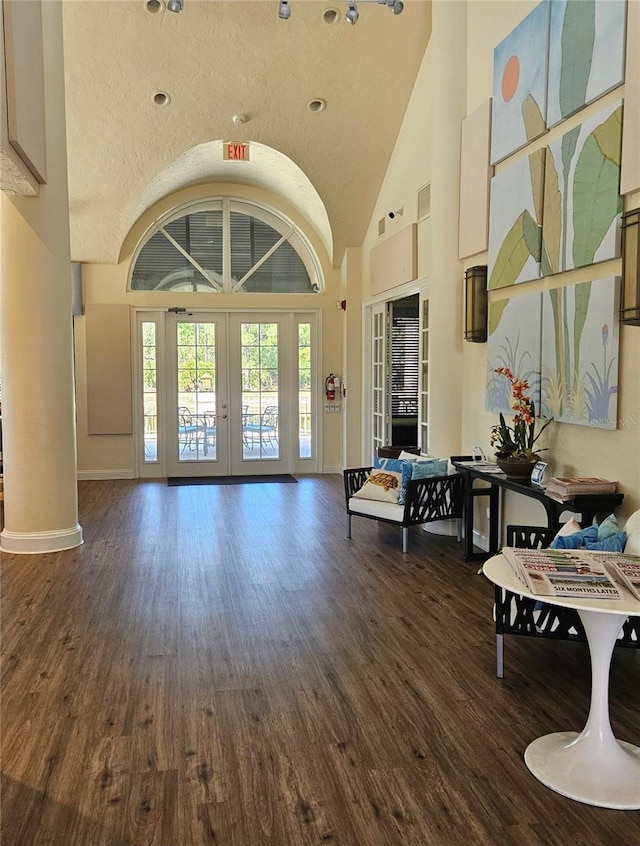 foyer entrance featuring french doors, high vaulted ceiling, baseboards, and dark wood finished floors
