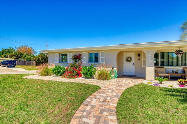 2605 Sunnybrook Dr, Sarasota, FL 34239 - ranch-style home featuring covered porch, fence, a front yard, and stucco siding