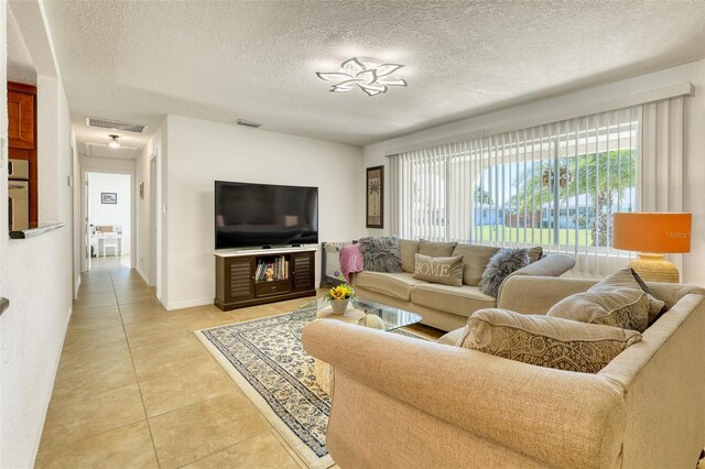 2605 Sunnybrook Dr, Sarasota, FL 34239 - living area with visible vents, a textured ceiling, and light tile patterned floors