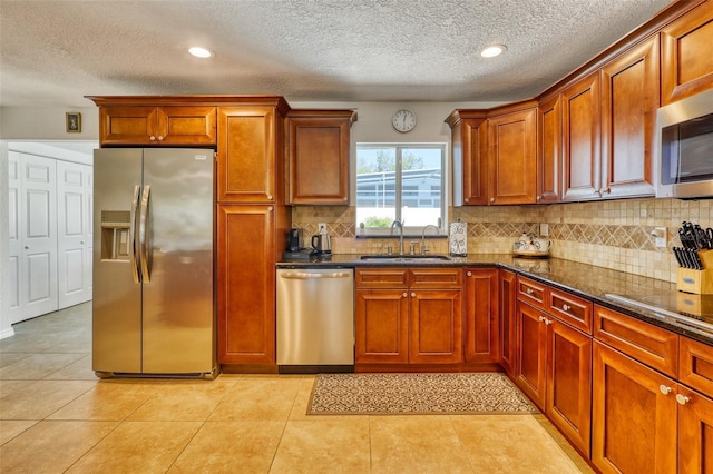 2605 Sunnybrook Dr, Sarasota, FL 34239 - kitchen featuring a textured ceiling, a sink, dark stone countertops, backsplash, and stainless steel appliances