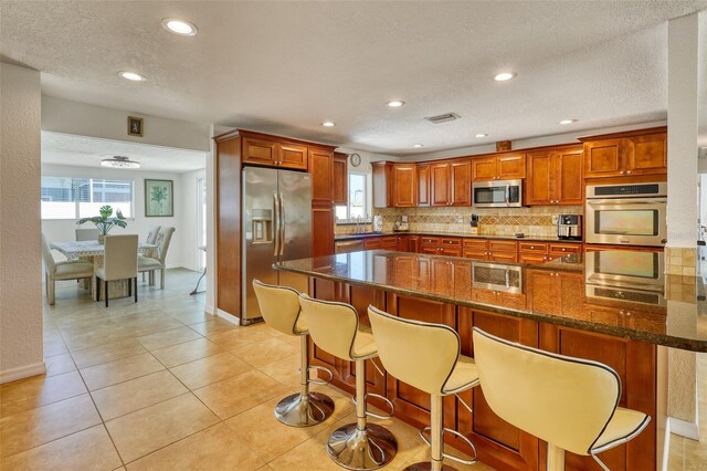 2605 Sunnybrook Dr, Sarasota, FL 34239 - kitchen featuring visible vents, backsplash, stainless steel appliances, and a wealth of natural light