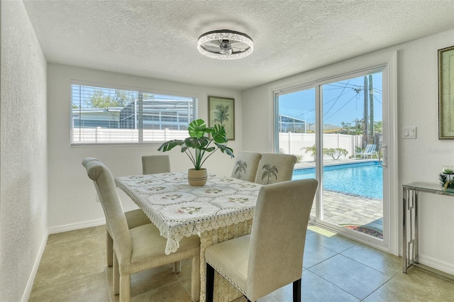 2605 Sunnybrook Dr, Sarasota, FL 34239 - dining area with a textured ceiling, a textured wall, light tile patterned flooring, and baseboards