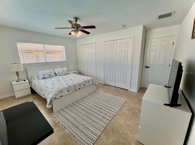 2605 Sunnybrook Dr, Sarasota, FL 34239 - bedroom with visible vents, a textured ceiling, two closets, and light tile patterned flooring