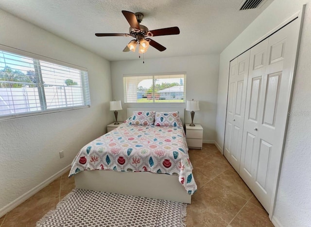 2605 Sunnybrook Dr, Sarasota, FL 34239 - bedroom with ceiling fan, baseboards, light tile patterned floors, visible vents, and a closet