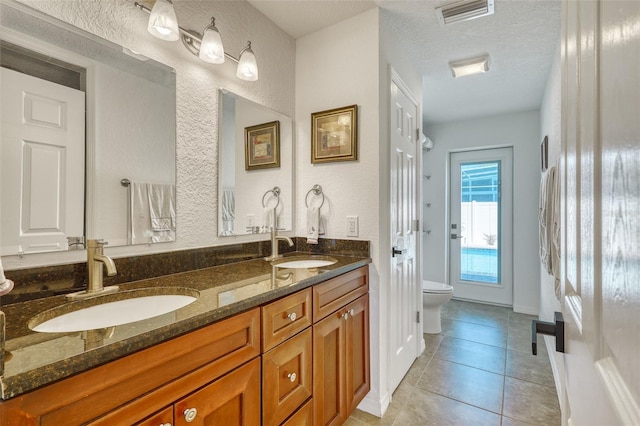 2605 Sunnybrook Dr, Sarasota, FL 34239 - bathroom with a textured wall, visible vents, a sink, and tile patterned floors