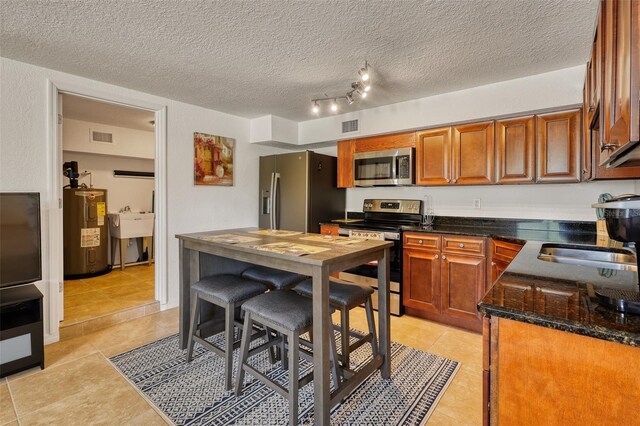 2605 Sunnybrook Dr, Sarasota, FL 34239 - kitchen featuring visible vents, appliances with stainless steel finishes, light tile patterned floors, and electric water heater