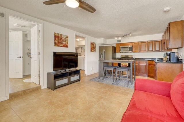 2605 Sunnybrook Dr, Sarasota, FL 34239 - living room featuring a ceiling fan, a textured ceiling, visible vents, and light tile patterned floors