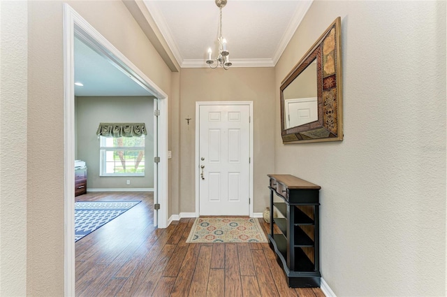 entrance foyer with dark wood-style floors, crown molding, baseboards, and a chandelier