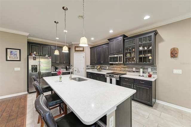 kitchen featuring light countertops, stainless steel appliances, a breakfast bar, decorative backsplash, and a sink