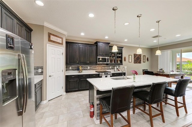 kitchen featuring light countertops, a kitchen bar, appliances with stainless steel finishes, and decorative backsplash