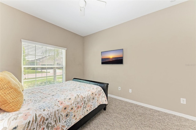 carpeted bedroom featuring baseboards and a ceiling fan