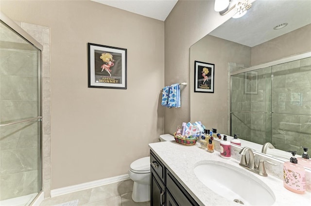 bathroom with vanity, toilet, baseboards, a shower stall, and tile patterned floors