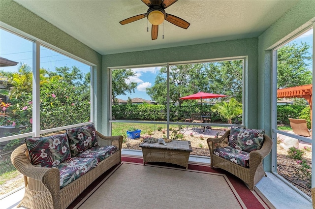 sunroom featuring a wealth of natural light, an outdoor hangout area, and ceiling fan