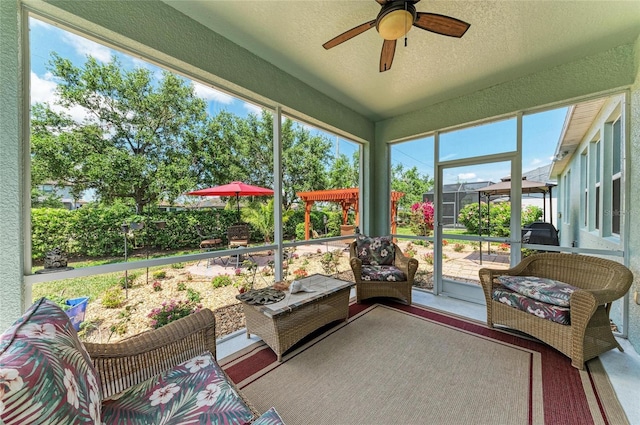 sunroom / solarium featuring a ceiling fan and an outdoor living space