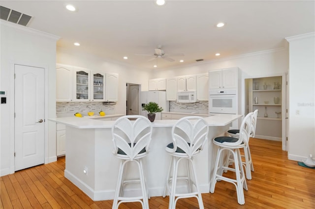1860 Citron St, Punta Gorda, FL 33980 - kitchen with white appliances, a kitchen bar, a ceiling fan, white cabinetry, and visible vents