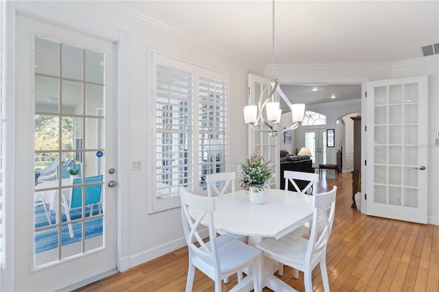 1860 Citron St, Punta Gorda, FL 33980 - dining space featuring light wood-type flooring, a chandelier, plenty of natural light, french doors, and crown molding