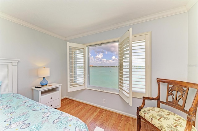 bedroom featuring ornamental molding, baseboards, and wood finished floors