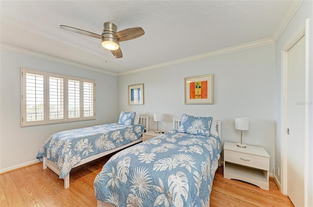 bedroom with crown molding, baseboards, and wood finished floors