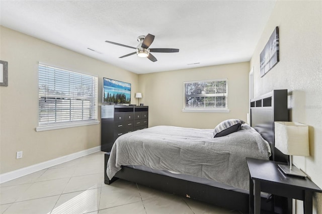 bedroom with baseboards, tile patterned floors, multiple windows, and a ceiling fan