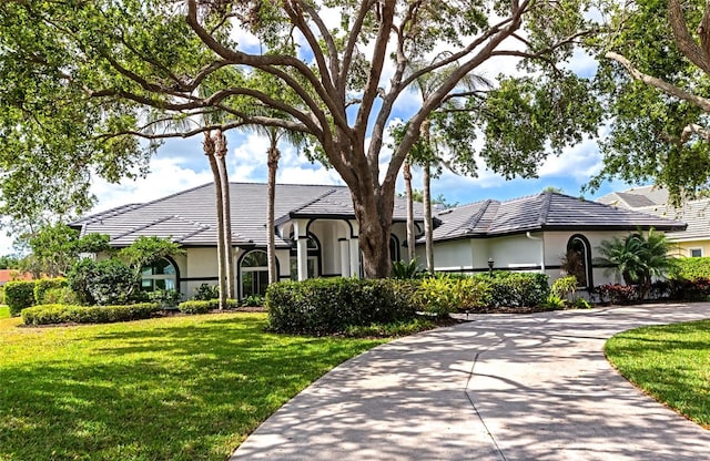 600 Eagle Watch Ln, Osprey, FL 34229 - view of front of property with stucco siding, a front yard, a tile roof, and concrete driveway