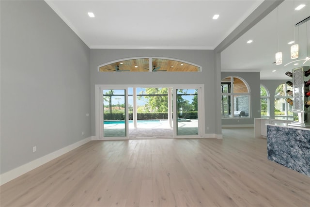 600 Eagle Watch Ln, Osprey, FL 34229 - unfurnished living room with light wood finished floors, ornamental molding, and recessed lighting