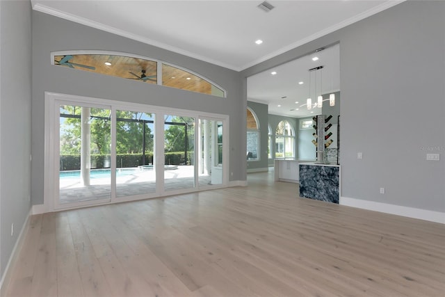 600 Eagle Watch Ln, Osprey, FL 34229 - unfurnished living room featuring ornamental molding, light wood-type flooring, and recessed lighting