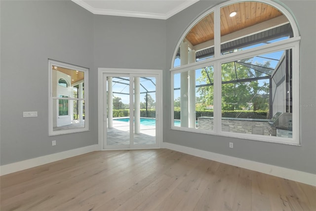 600 Eagle Watch Ln, Osprey, FL 34229 - empty room with a sunroom, wood finished floors, ornamental molding, a towering ceiling, and wooden ceiling
