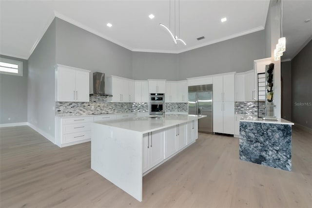 600 Eagle Watch Ln, Osprey, FL 34229 - kitchen with wall chimney range hood, stainless steel appliances, crown molding, backsplash, and light wood-type flooring