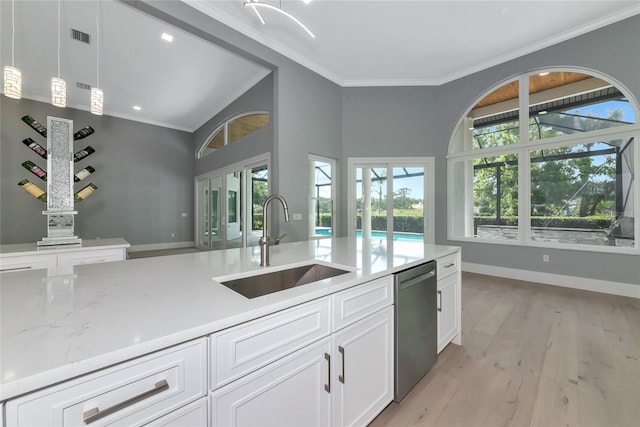 600 Eagle Watch Ln, Osprey, FL 34229 - kitchen with dishwasher, crown molding, hanging light fixtures, white cabinets, and light wood-style flooring