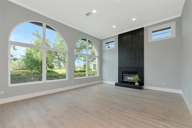 600 Eagle Watch Ln, Osprey, FL 34229 - unfurnished living room with crown molding, light wood-style flooring, a fireplace, and recessed lighting