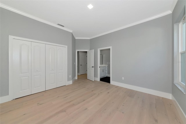 600 Eagle Watch Ln, Osprey, FL 34229 - unfurnished bedroom featuring ornamental molding, wood finished floors, a closet, and connected bathroom