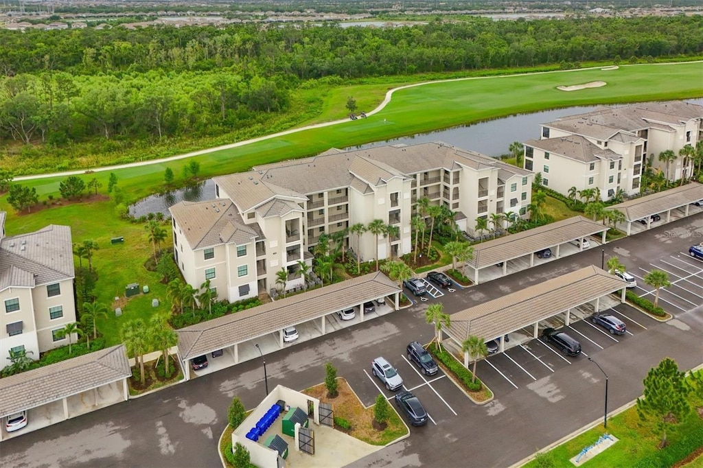drone / aerial view with a water view and view of golf course