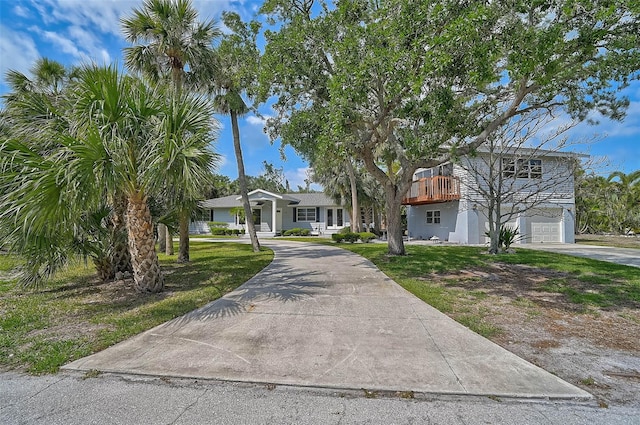 view of front of property with concrete driveway, a garage, and a front yard