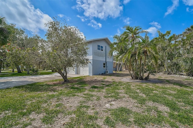 view of side of home with driveway and an attached garage