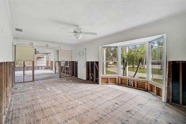 unfurnished living room featuring ornamental molding and ceiling fan