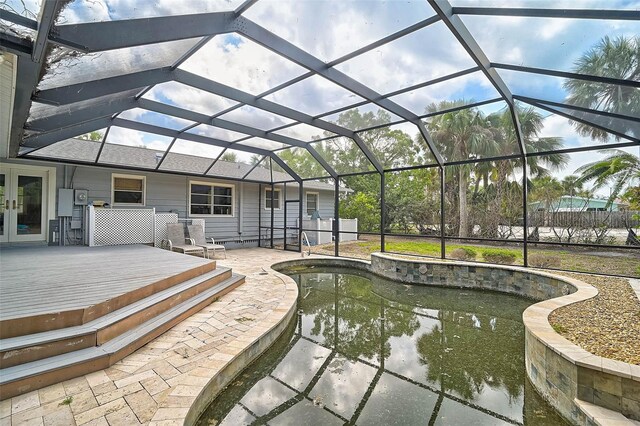 view of patio featuring french doors, a wooden deck, an outdoor pool, and glass enclosure