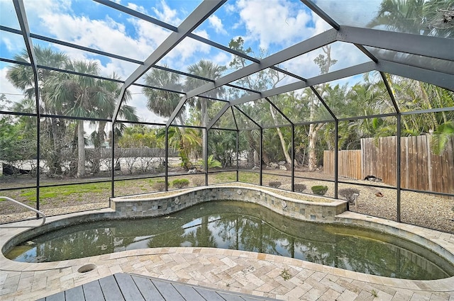 view of swimming pool with a lanai and a fenced backyard